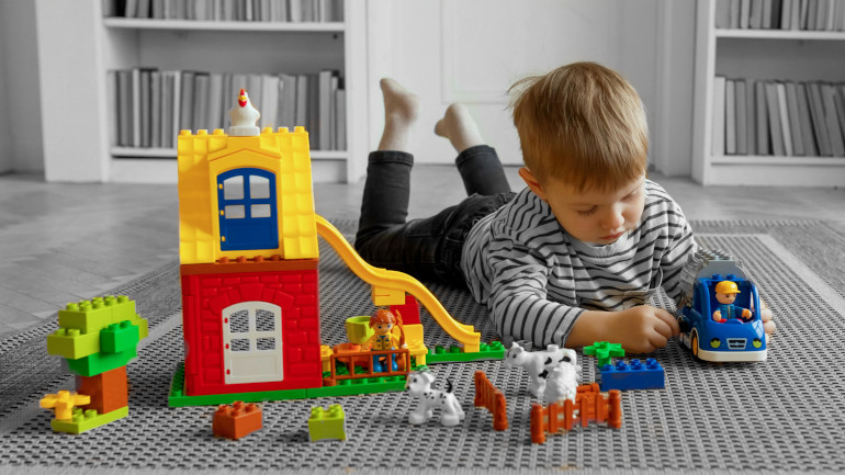 Enfant qui joue avec des jouets en plastique